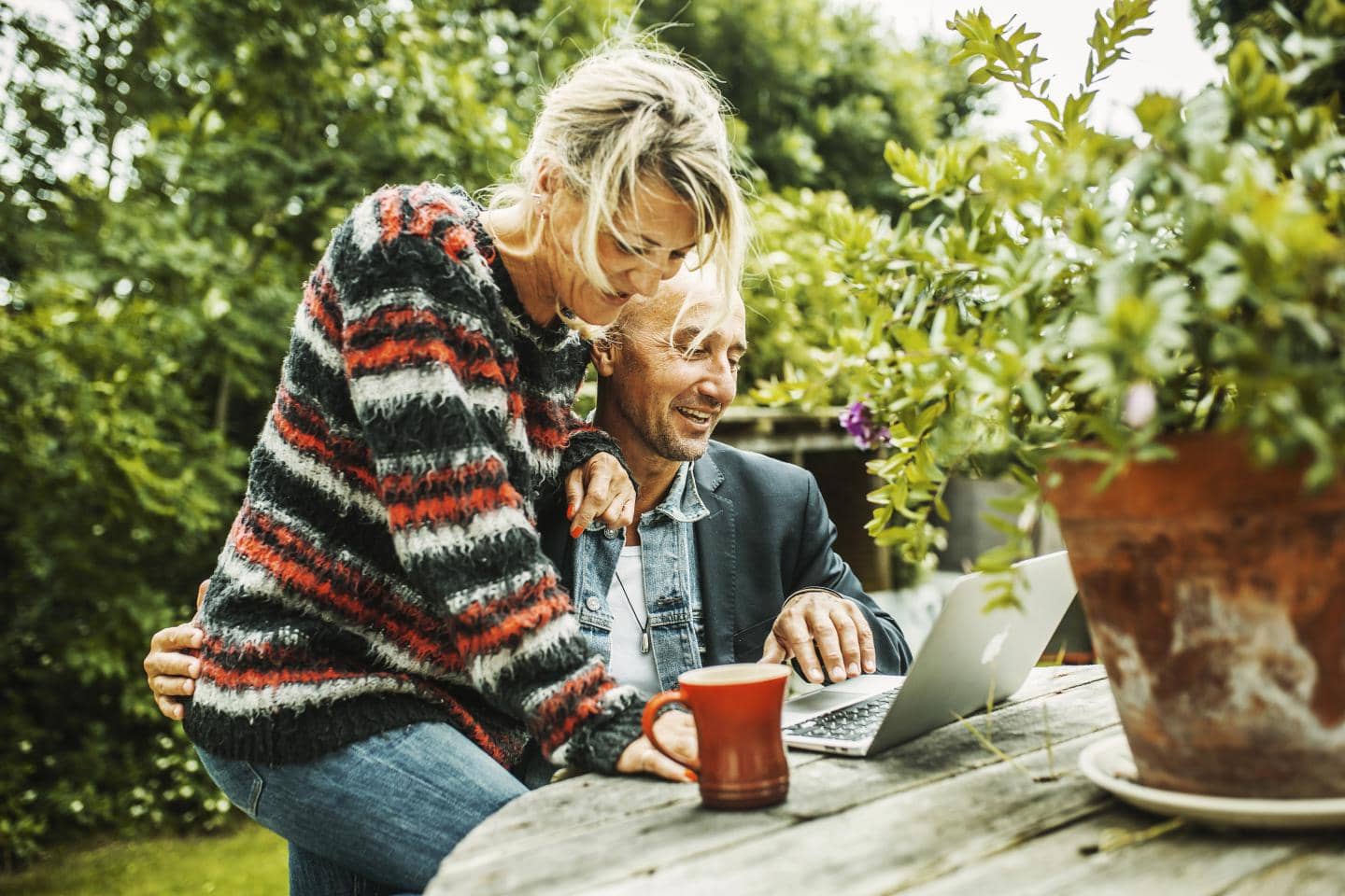 kreative mennesker ser på design på en computer i haven - de er medlemmer af teknisk landsforbund og er kunder i TJM forsikring