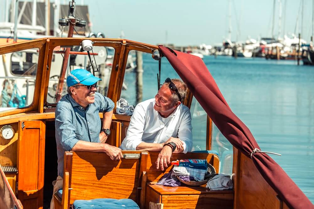 To mænd taler sammen på en båd - de er så heldige at kunne få rabat på forsikringer gennem deres fagforbund CS